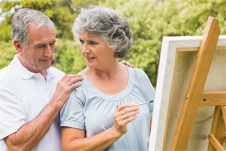 Cheerful retired woman painting on canvas and talking with husband in the park on sunny day Stock Photo - Budget Royalty-Free & Subscription, Code: 400-06934234