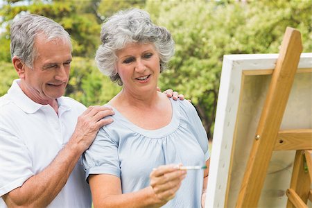 Happy retired woman painting on canvas and talking with husband in the park on sunny day Stock Photo - Budget Royalty-Free & Subscription, Code: 400-06934235