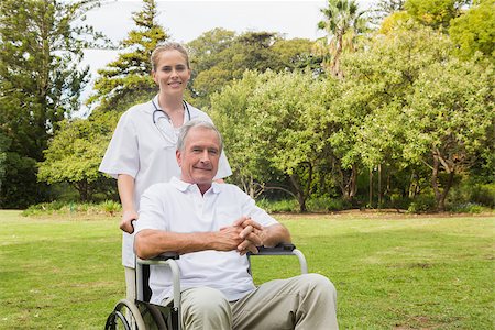 simsearch:6109-06684830,k - Man sitting in a wheelchair with his nurse pushing him outside in the park Stock Photo - Budget Royalty-Free & Subscription, Code: 400-06934237