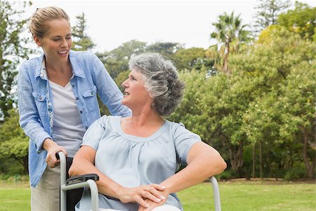 simsearch:6109-06684838,k - Smiling mature woman in wheelchair talking with daughter on sunny day in park Foto de stock - Super Valor sin royalties y Suscripción, Código: 400-06934257