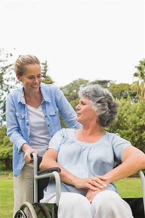 simsearch:6109-06684838,k - Cheerful mature woman in wheelchair talking with daughter on sunny day in park Foto de stock - Super Valor sin royalties y Suscripción, Código: 400-06934258