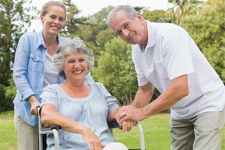 simsearch:6109-06684830,k - Smiling woman in wheelchair with daughter and husband looking at camera in the park Stock Photo - Budget Royalty-Free & Subscription, Code: 400-06934264