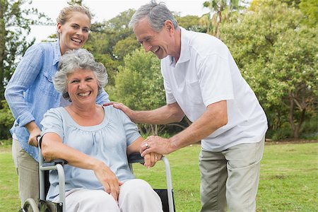 simsearch:6109-06684830,k - Happy woman in wheelchair with daughter and husband in the park laughing on sunny day Stock Photo - Budget Royalty-Free & Subscription, Code: 400-06934263