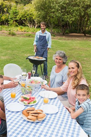 Happy extended family having a barbecue smiling at camera outside Stock Photo - Budget Royalty-Free & Subscription, Code: 400-06934300