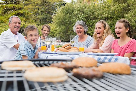 Laughing family having a barbecue in the park together looking at camera Stock Photo - Budget Royalty-Free & Subscription, Code: 400-06934310