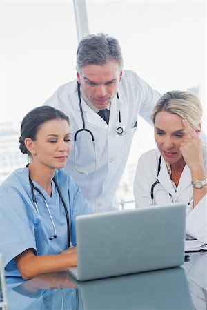 simsearch:6109-06781530,k - Cheerful doctors working together on laptop in medical office Photographie de stock - Aubaine LD & Abonnement, Code: 400-06934640