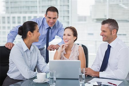 simsearch:400-06929750,k - Cheerful colleagues around laptop working together in bright office Stock Photo - Budget Royalty-Free & Subscription, Code: 400-06934719