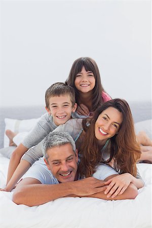 simsearch:400-06930138,k - Parents with their children lying on bed at home Stock Photo - Budget Royalty-Free & Subscription, Code: 400-06930067