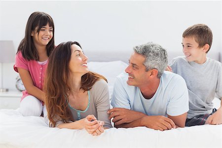 simsearch:400-06930138,k - Smiling family talking together on bed at home Stock Photo - Budget Royalty-Free & Subscription, Code: 400-06930068