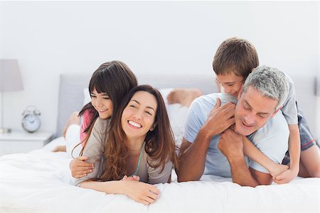 simsearch:400-06930138,k - Cute family lying together on bed Stock Photo - Budget Royalty-Free & Subscription, Code: 400-06930069