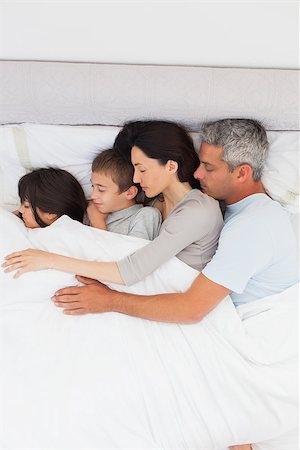 simsearch:400-06930138,k - Parent sleeping with their children in bed at home Stock Photo - Budget Royalty-Free & Subscription, Code: 400-06930077