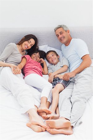 simsearch:400-06930138,k - Family lying on bed at home Stock Photo - Budget Royalty-Free & Subscription, Code: 400-06930078