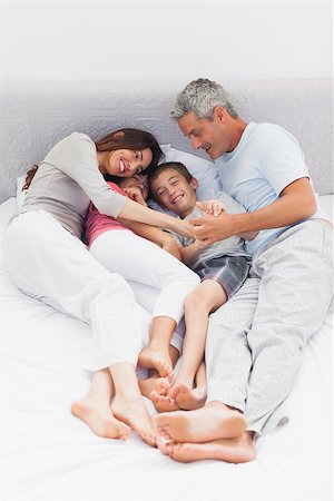 simsearch:400-06930138,k - Smiling family lying on bed at home Stock Photo - Budget Royalty-Free & Subscription, Code: 400-06930079