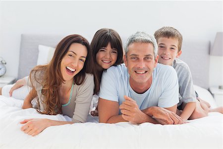 simsearch:400-06930138,k - Happy family lying together on bed Stock Photo - Budget Royalty-Free & Subscription, Code: 400-06930070