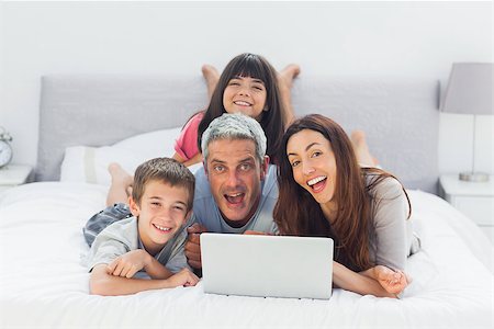 simsearch:400-06930138,k - Funny family lying on bed using their laptop at home Stock Photo - Budget Royalty-Free & Subscription, Code: 400-06930088