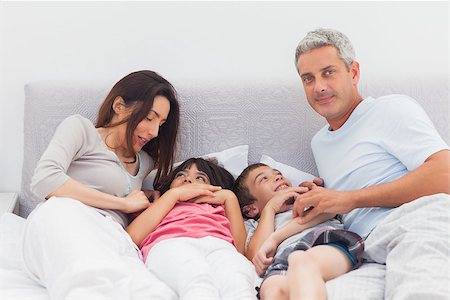 simsearch:400-06930138,k - Cheerful family lying on bed at home Stock Photo - Budget Royalty-Free & Subscription, Code: 400-06930081