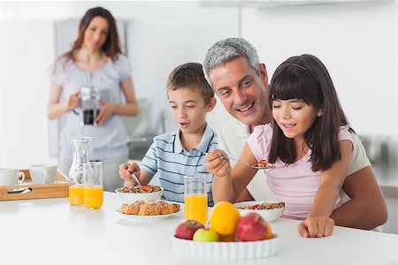 simsearch:400-06930138,k - Happy family eating breakfast in kitchen together at home Stock Photo - Budget Royalty-Free & Subscription, Code: 400-06930125