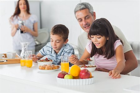 simsearch:400-06930138,k - Cute family eating breakfast in kitchen together at home Stock Photo - Budget Royalty-Free & Subscription, Code: 400-06930123