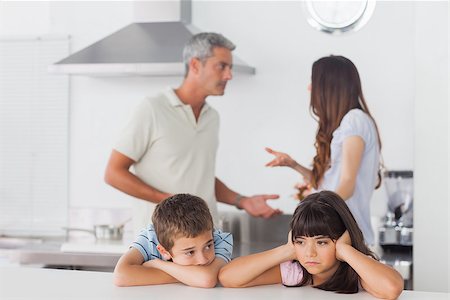 simsearch:400-06930138,k - Unhappy siblings sitting in kitchen with their parents who are fighting at home loudly Stock Photo - Budget Royalty-Free & Subscription, Code: 400-06930136