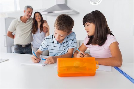 simsearch:400-06930138,k - Siblings drawing together in kitchen with their parents smiling at home Stock Photo - Budget Royalty-Free & Subscription, Code: 400-06930132
