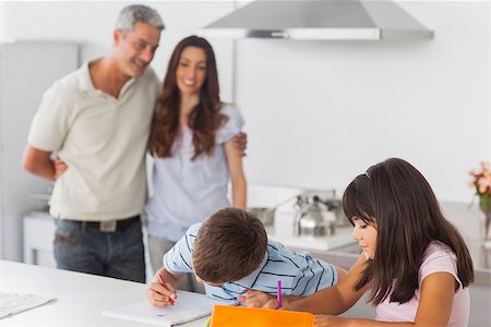 simsearch:400-06930138,k - Cute siblings drawing together in kitchen with their parents smiling at home Stock Photo - Budget Royalty-Free & Subscription, Code: 400-06930133
