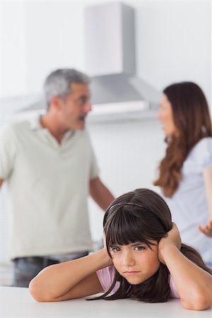simsearch:400-06930138,k - Angry couple having dispute in front of their daughter blocking her ears sitting in kitchen at home Stock Photo - Budget Royalty-Free & Subscription, Code: 400-06930141