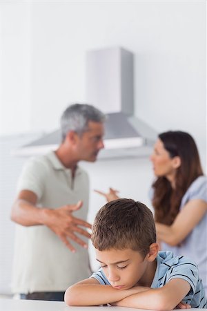 simsearch:400-06930138,k - Couple having dispute in front of their sad son sitting in kitchen at home Stock Photo - Budget Royalty-Free & Subscription, Code: 400-06930142