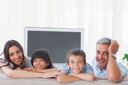 simsearch:400-06930138,k - Family in sitting room smiling at camera at home Stock Photo - Budget Royalty-Free & Subscription, Code: 400-06930164