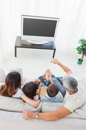 family on sofa popcorn - Family with popcorn watching their television on sofa in the sitting room Stock Photo - Budget Royalty-Free & Subscription, Code: 400-06930169