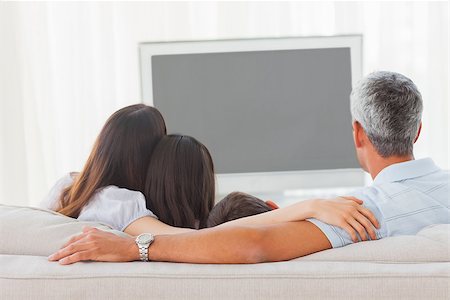 simsearch:632-01149212,k - Family watching television together on sofa at home Stockbilder - Microstock & Abonnement, Bildnummer: 400-06930162