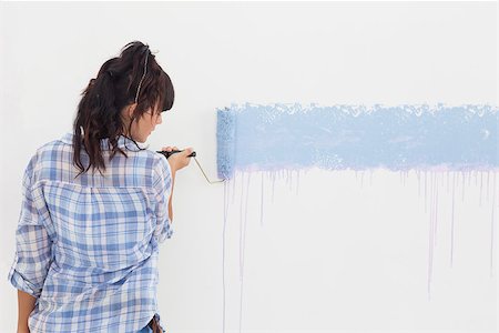 Woman painting wall blue with paint roller on blank wall Photographie de stock - Aubaine LD & Abonnement, Code: 400-06931051