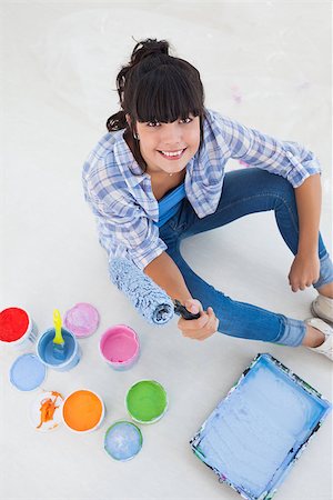 Happy woman sitting on floor with paint for decorating looking at camera Photographie de stock - Aubaine LD & Abonnement, Code: 400-06931065