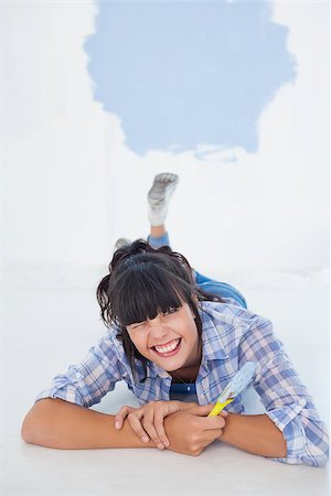 Brunette woman lying on floor holding paint brush winking at camera Photographie de stock - Aubaine LD & Abonnement, Code: 400-06931072