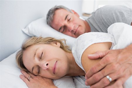 simsearch:400-06891122,k - Calm couple sleeping and spooning in bed in bedroom at home Photographie de stock - Aubaine LD & Abonnement, Code: 400-06931227