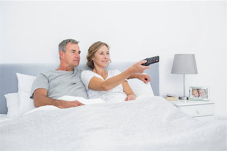 Happy couple watching tv in bed at home in bedroom Stock Photo - Budget Royalty-Free & Subscription, Code: 400-06931245