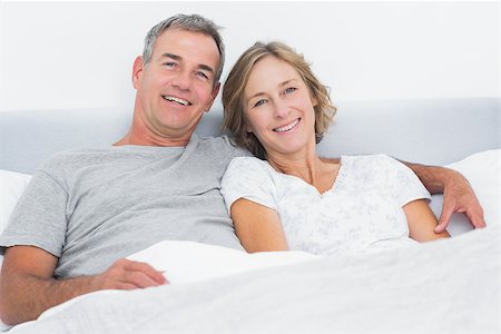 simsearch:400-06891126,k - Happy couple cuddling in bed looking at camera at home in bedroom Stock Photo - Budget Royalty-Free & Subscription, Code: 400-06931252