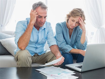 simsearch:400-07333928,k - Worried couple paying their bills online with laptop at home in the living room Stock Photo - Budget Royalty-Free & Subscription, Code: 400-06931536