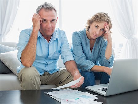 simsearch:400-07333928,k - Anxious couple paying their bills online with laptop at home in the living room Stock Photo - Budget Royalty-Free & Subscription, Code: 400-06931537