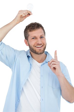 Smiling model holding a bulb above his head on white background Stock Photo - Budget Royalty-Free & Subscription, Code: 400-06931748