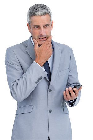 simsearch:400-07141016,k - Thoughtful businessman touching his chin holding cellphone on white background Stockbilder - Microstock & Abonnement, Bildnummer: 400-06932165