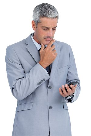 simsearch:400-07141016,k - Thoughtful businessman against white background touching his chin and looking at his phone Stockbilder - Microstock & Abonnement, Bildnummer: 400-06932166