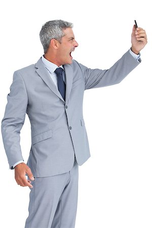 simsearch:400-07139155,k - Furious businessman against white background answering phone Stock Photo - Budget Royalty-Free & Subscription, Code: 400-06932174