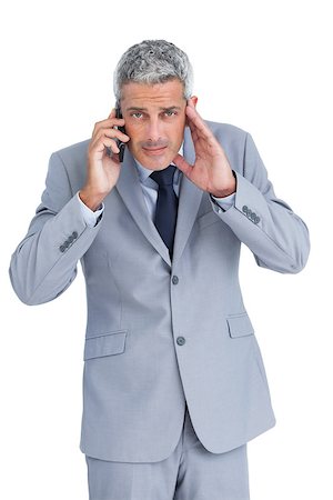 simsearch:400-07139155,k - Concentrated businessman answering phone against white background Stock Photo - Budget Royalty-Free & Subscription, Code: 400-06932170