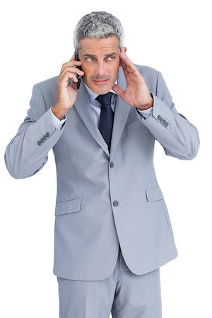 simsearch:400-07139155,k - Attentive businessman answering phone against white background Stock Photo - Budget Royalty-Free & Subscription, Code: 400-06932171
