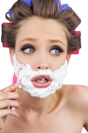 Shocked young model in hair curlers posing with razor on white background Stock Photo - Budget Royalty-Free & Subscription, Code: 400-06932449