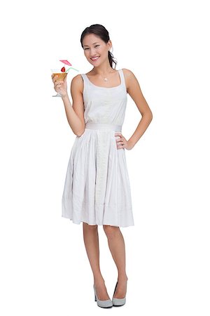 fresh-faced - Relaxed brunette posing with cocktail against white background Stock Photo - Budget Royalty-Free & Subscription, Code: 400-06932499