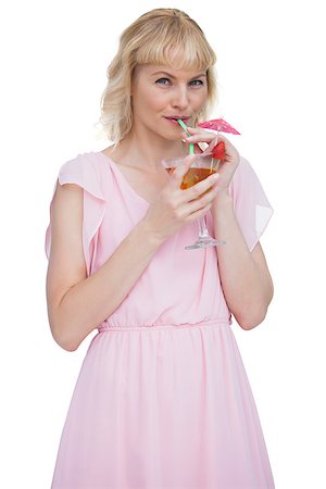 fresh-faced - Pretty blond woman drinking cocktail against white background Stock Photo - Budget Royalty-Free & Subscription, Code: 400-06932535