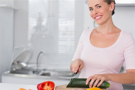simsearch:400-06891385,k - Pretty woman cutting vegetables in the kitchen Stock Photo - Budget Royalty-Free & Subscription, Code: 400-06932552