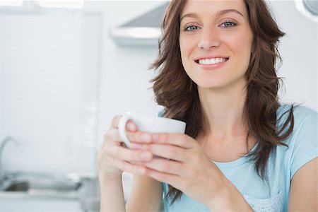 simsearch:400-06932687,k - Radiant brunette drinking coffee in her kitchen Stock Photo - Budget Royalty-Free & Subscription, Code: 400-06932675