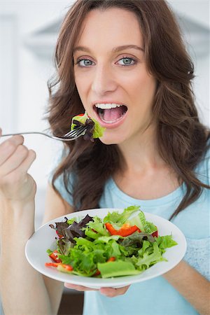 simsearch:400-06932687,k - Healthy brunette having salad in her kitchen Stock Photo - Budget Royalty-Free & Subscription, Code: 400-06932686